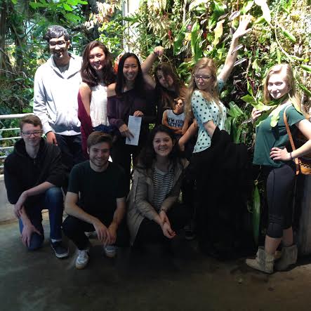 The science club poses in front of a plant display in the rainforest display. 