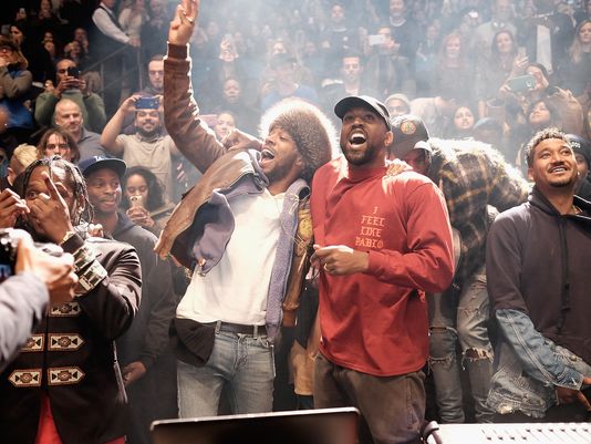 West and fellow artist Kid Cudi having a good time at Wests Yeezy Season 3 Fashion Show; Madison Square Garden