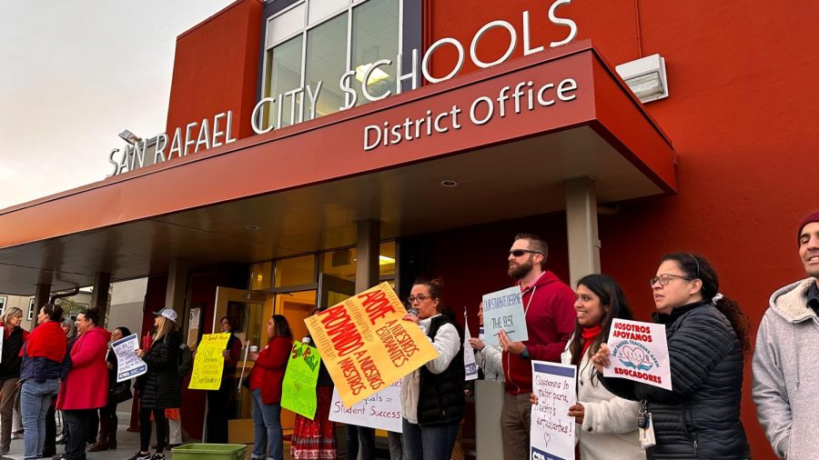 Outside the district office, teachers hold up signs in support of SRTA educators.