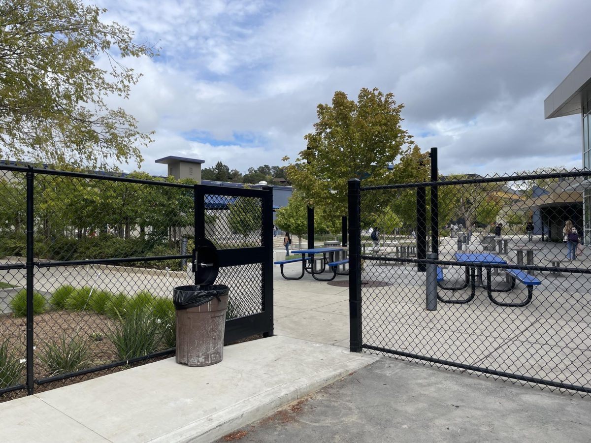 The gate near the tennis court parking lot propped open after school.