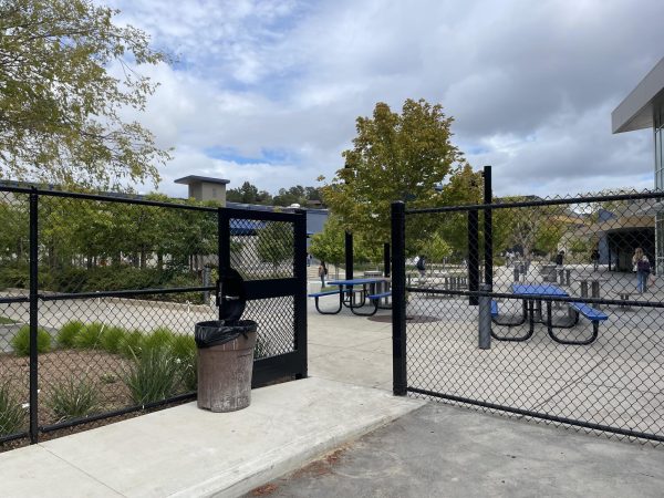 The gate near the tennis court parking lot propped open after school.