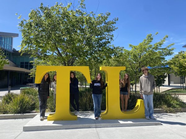Journalism students pose in front of the new "TL" sign